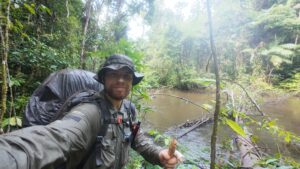 Swiss adventurer Loic Cappellin standing next to a river in the Amazon rainforest of French Guiana