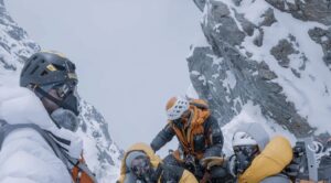 Climbers on a ridge in a foggy day.