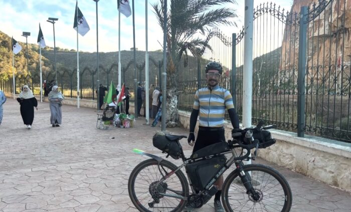 Swiss cyclist Adrien Liechti standing at the border between Algeria and Morocco