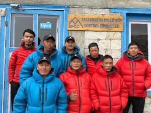 A Sherpa team in red and clue jackets pose in front of the the Sagarmatha Pollution Control Committee (SPCC)’s HQs in Namche Bazaar.