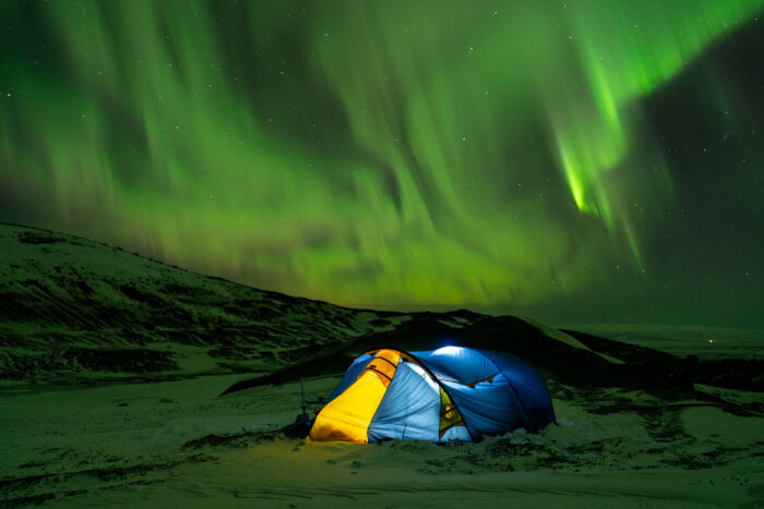 Weissbaum's tent surrounded by strong northern lights