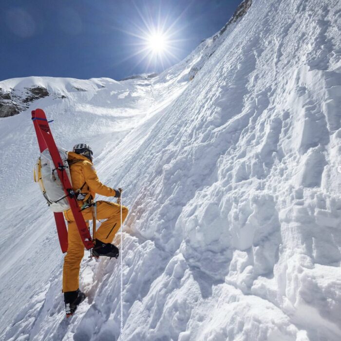 Jim Morrison on a steep snow slope towards a sunny summit of Everest