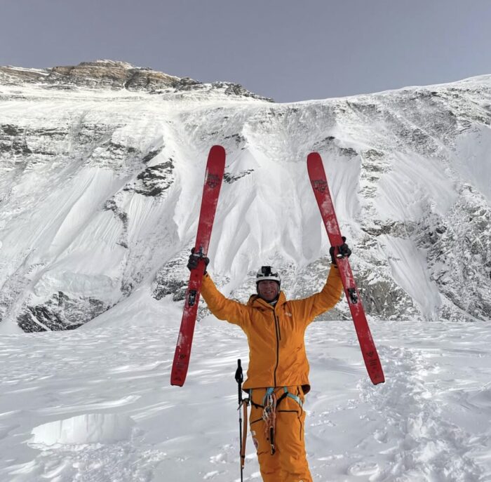 Morrison rises his skis in triumph while standing on the Rongbuk glacier