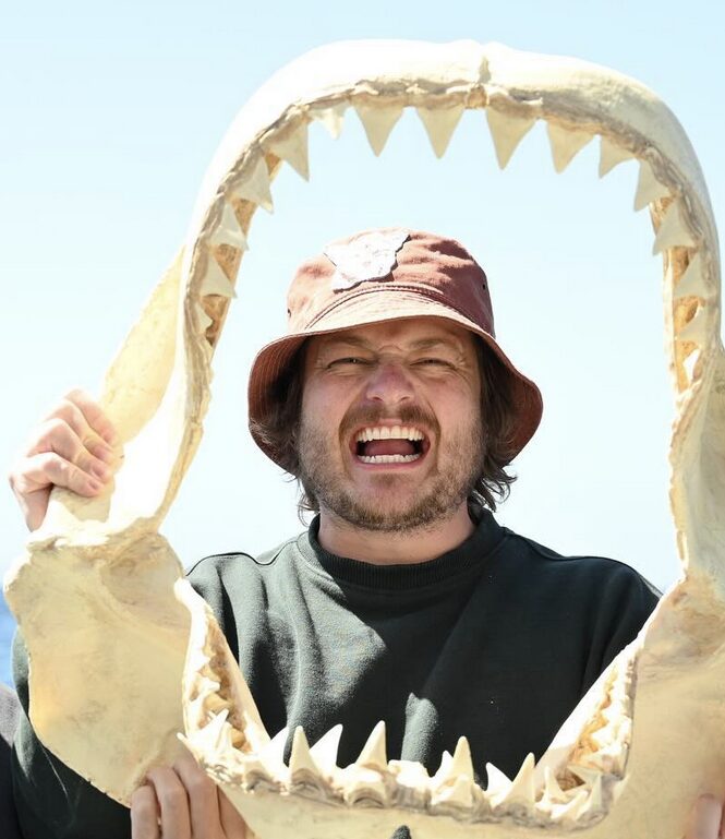 guy framed by shark skeleton jaws