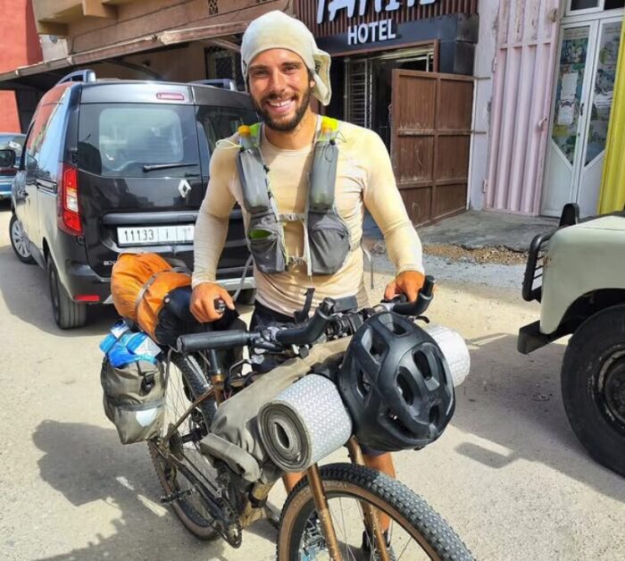 Lorenzo Barone standing with his bike in the coastal town of Dakhla, Morocco