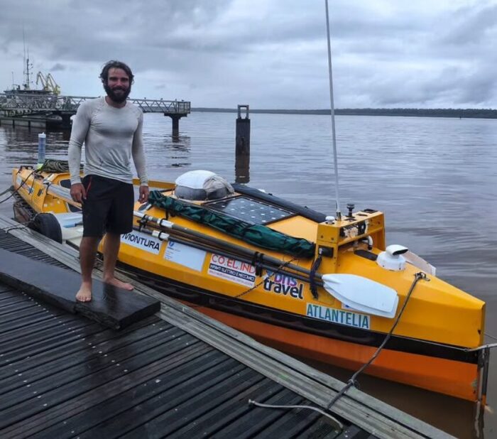 Italian adventurer stands next to his mooredboat after crossing the Atlantic