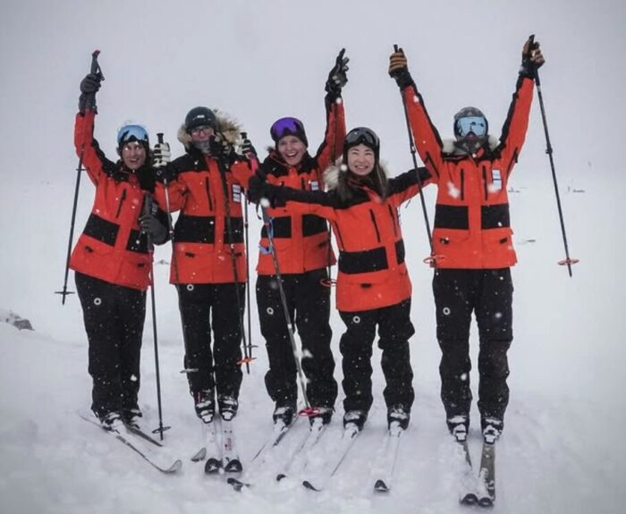 The "Girls Trip Team" standing in a line on skis while training in Norway