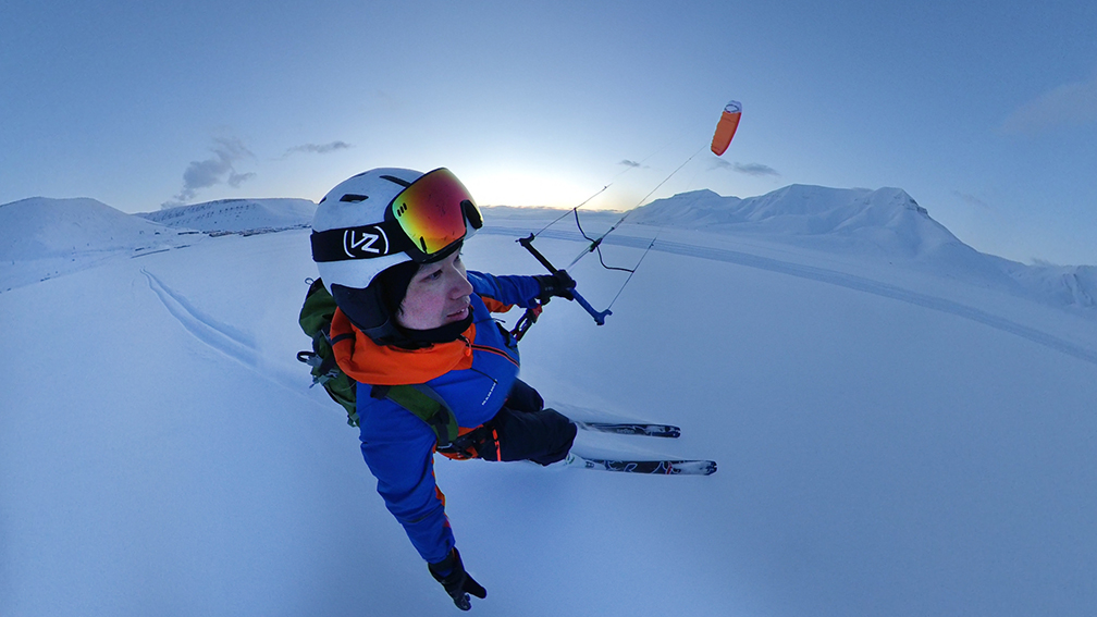 Man skiing with snow kite aloft in the air
