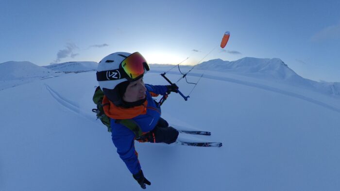 Man skiing with snow kite aloft in the air