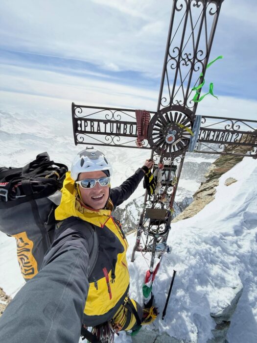 Giuseppe Vidoni poses by the cross marking the summit of Matterhorn. 