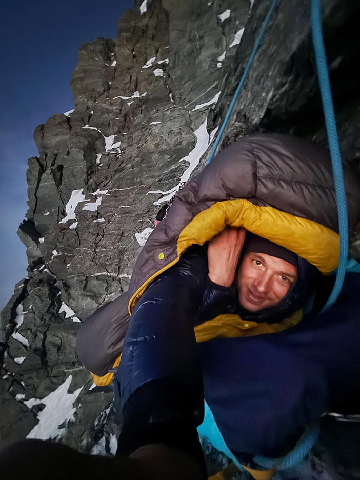 Climber looking cold while hanging on the void on Matterhorn.