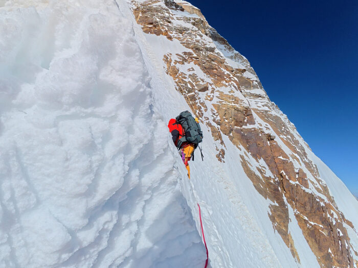 A climber on a steep snow couloir. 