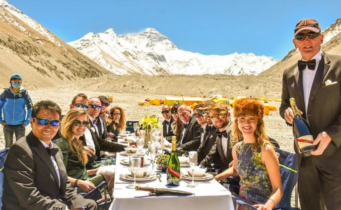 A table of people sit at Everest Base Camp (north side) for a high altitude banquet