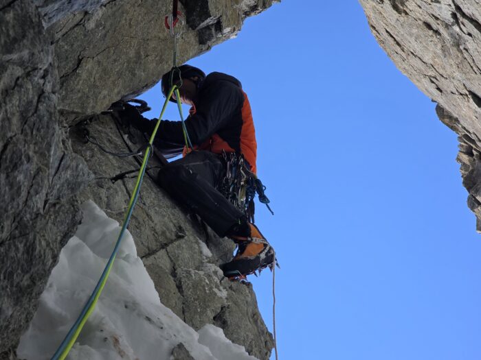 A climber exiting a rock and ice gully. 