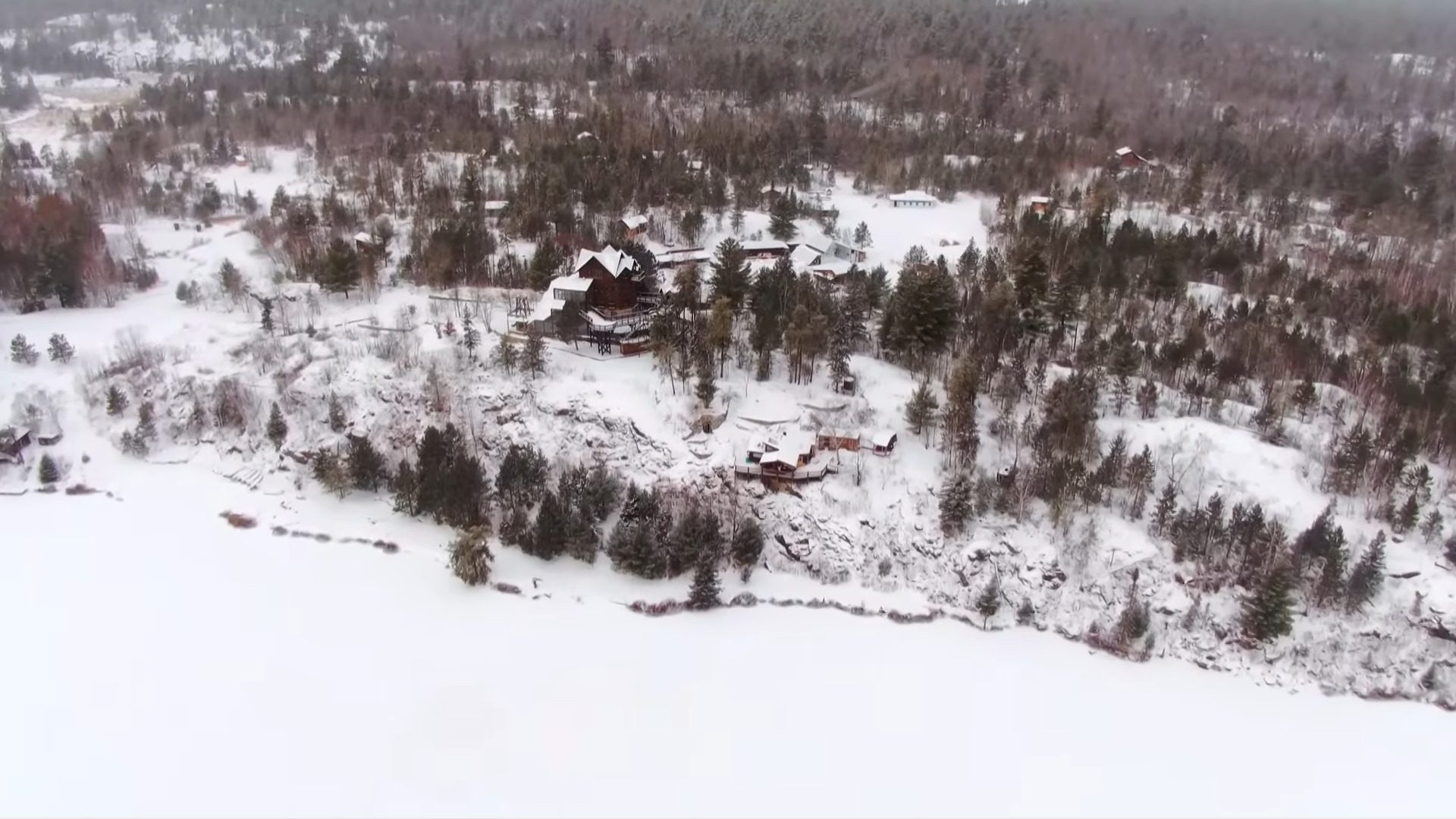 A complex of several modern buildings and cabins, in a snowy landscape.