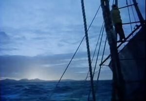 a man on the rigging of a small boat