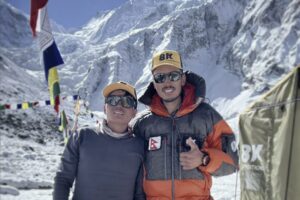 Two nepalaese climbers at a base camp with Annapurna in background.