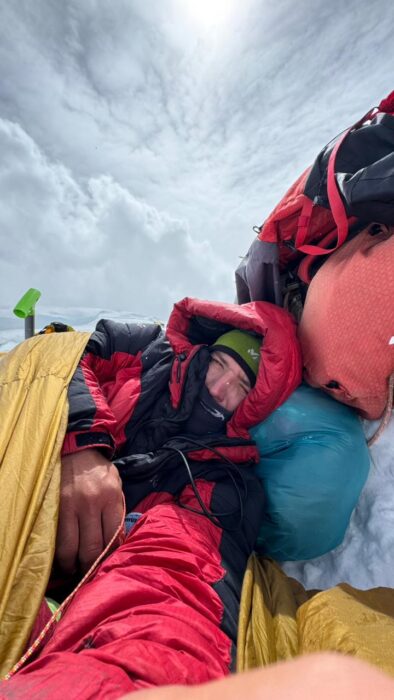 A climber on an open bivy high up on Manaslu.