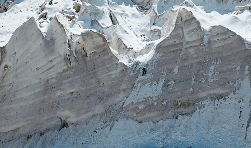 climber ice climbing on giant serac