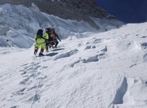 Two climbers on a steep snow slope.