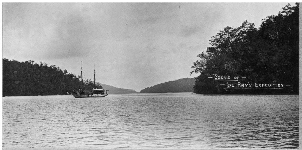 Old photo of a small boat in a jungle bay