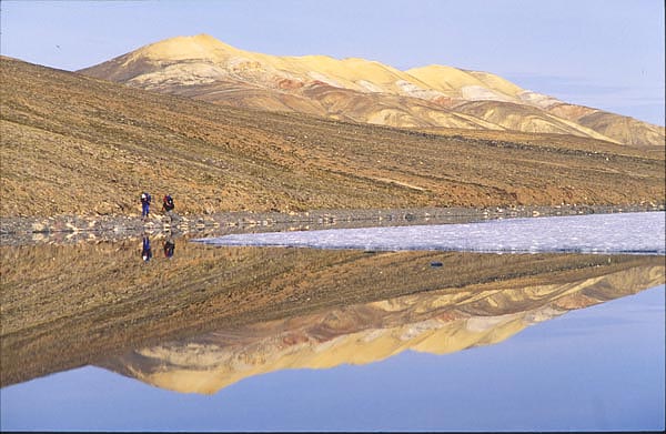 two hikers beside lake