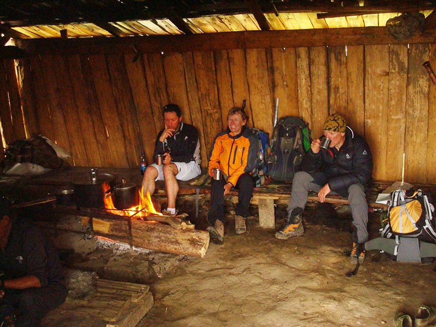 three climbers having tea in what looks like a manger