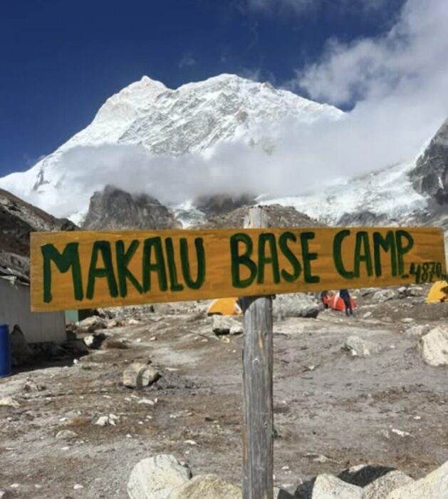 A sign marks Makalu's Base camp, with the mountain in background. 