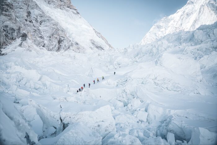 A line of 8-10 Sherpas heading for the top of the Khumbu Icefall among gigantic chunks of ice.