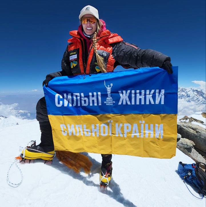 woman holding banner on mountaintop