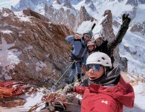 Young climbers smile on the summit of the grandes Jorasses. Alps