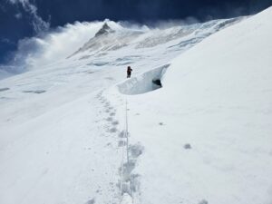A climber leaving a single set of footprints on the snow on Manaslu.
