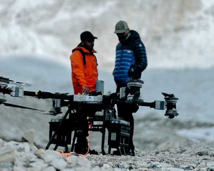 Two pilots with a big drone in front at Everest Base Camp
