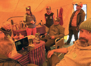 Climbers sitting in a big tent around a table.