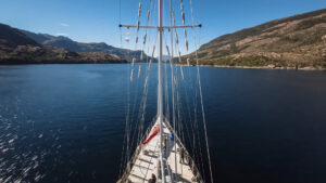View from a small sailing vessel showing the bow and a bay