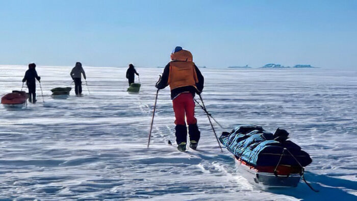 Skiers pulling sled on the Greenland ice sheet