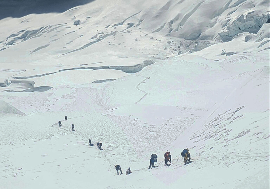 Climbers on a snowy glacier section of Kangchenjunga.