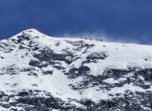 Climbners about to reach the summit of Everest today, along a windy ridge.