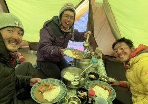 Three Japanese climbers at dinner in a BC tent.
