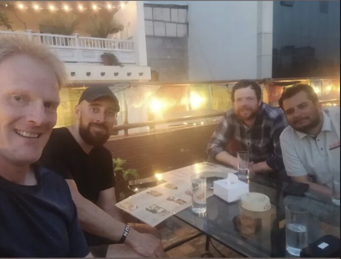 Four men at a table in a restaurant. 