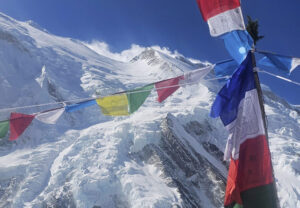 Prayer flags on a chorten's pole and kangchenjunga in background.
