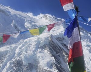 Prayer flags on a chorten's pole and kangchenjunga in background.