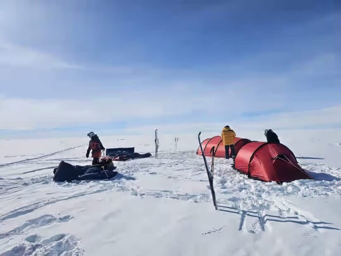 Adventurers stand outside their camp on the Greenland ice sheet