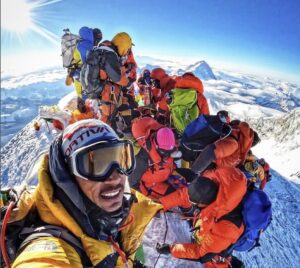 Pemba Gelje takes a selfie of his summit group on top of everest in a sunny day.