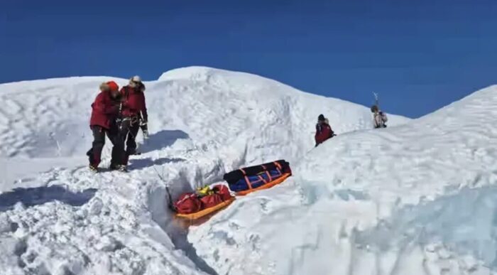Four adventurers haul their sleds over the glacier at the edge of the Greenland ice sheet
