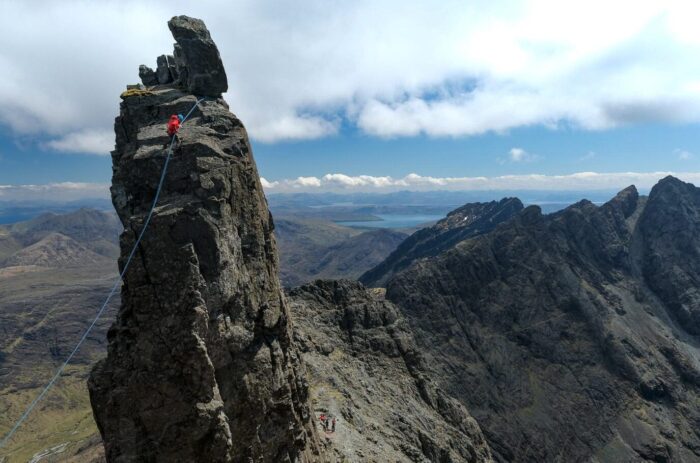 A climber rappelling a large rock tower on the Cuillin Ridge known as the Inaccessible Pinnacle