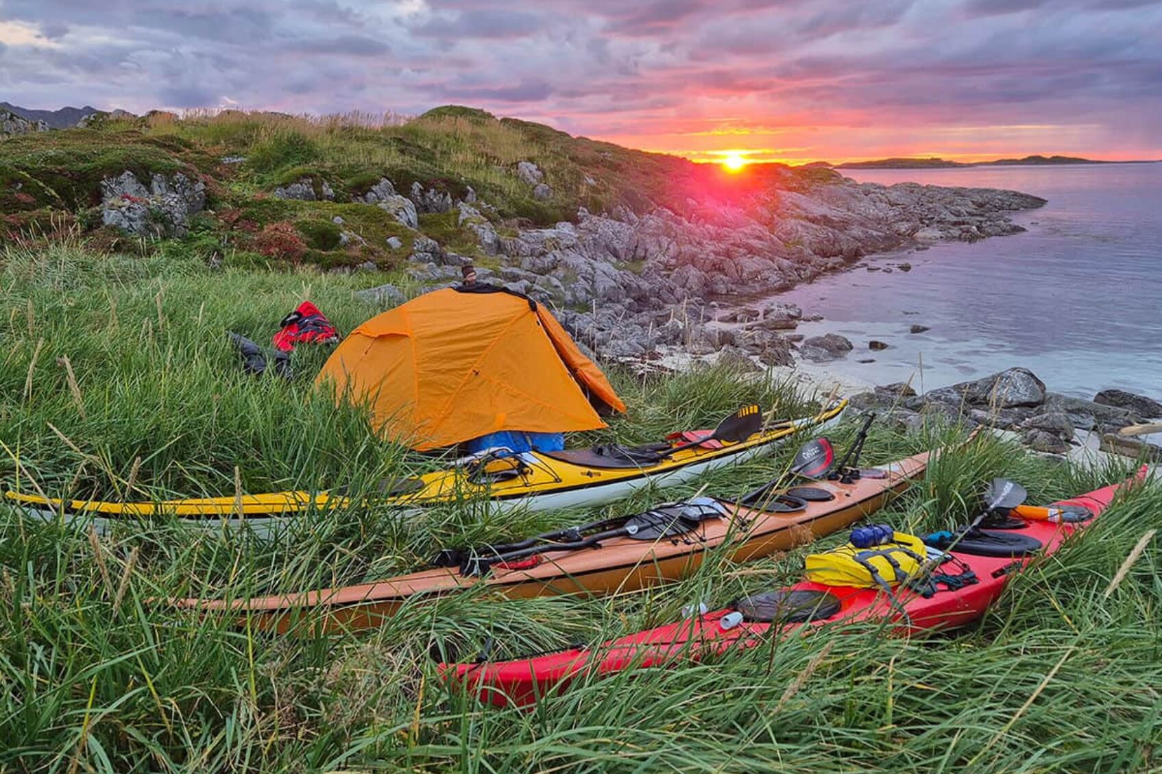 A sunset picture of the camp set up by David Priddis on Norway's northern coast, with three Nordkapp kayaks.