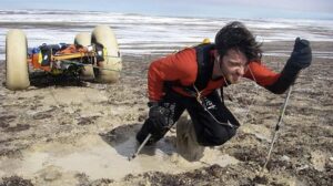 guy pulling sled through mud