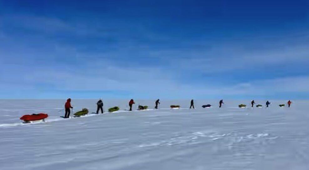 long line of manhaulers on snow