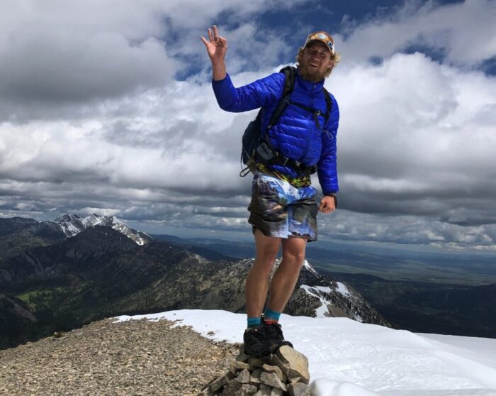 Hiker Wesley Tils standing atop of an unknown mountain
